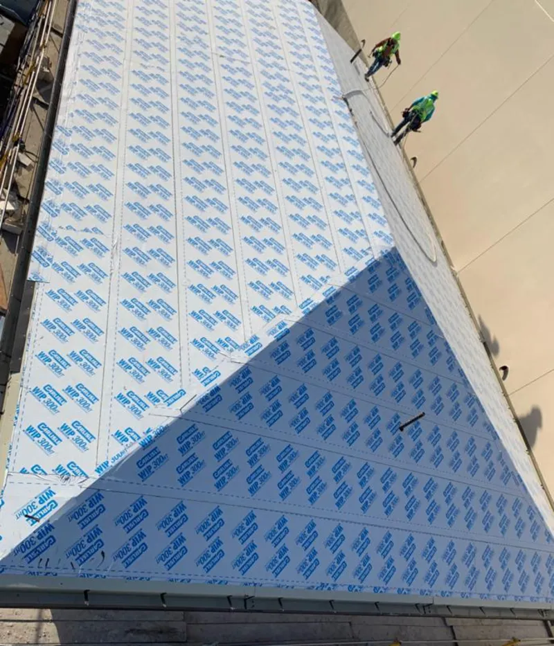 Professional roofers installing underlayment on a metal roof in Bergenfield